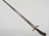an old sword with a wooden handle on a white surface