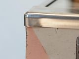 a close up view of a metal box with a red button