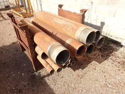 a pile of pipes sitting on the ground in front of a building