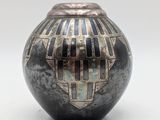a black and silver vase with geometric designs on it