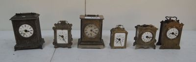 cinq horloges de tailles différentes posées sur une surface blanche
