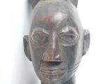 an old wooden statue of a woman with a ponytail on her head