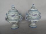 une paire de vases bleus et blancs munis d'anses, posés sur une table