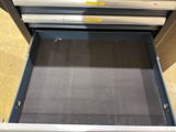 an open drawer with a metal drawer inside of it