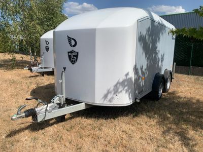 une remorque blanche garée dans l'herbe