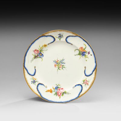 une assiette décorée de fleurs et de feuilles sur fond blanc
