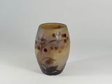 a brown vase with flowers on it on a white surface