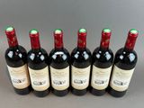 six bouteilles de vin alignées sur une table