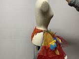 woman standing next to a mannequin with a colorful skirt on it