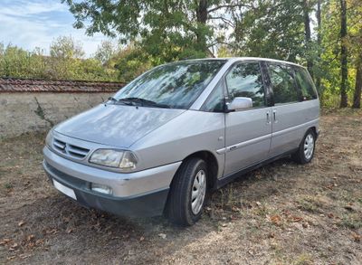 une camionnette argentée garée dans l'herbe