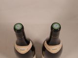 two bottles of wine sitting next to each other on a table