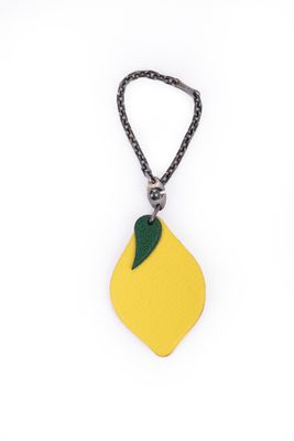 un gros plan d'un citron suspendu à une chaîne sur fond blanc