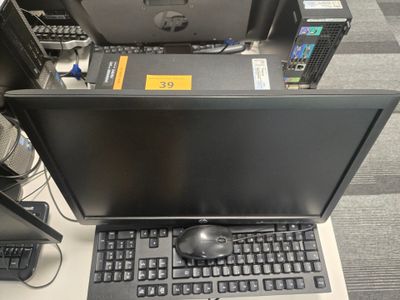 un ordinateur portable posé sur un bureau, avec un clavier et une souris