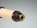 a close up of a pipe with a wooden handle on a gray background