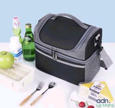 un sac-repas posé sur une table, à côté d'une bouteille de bière