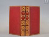 un vieux livre à la couverture rouge et aux bordures dorées sur un fond blanc