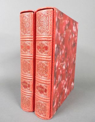 deux livres rouges posés l'un sur l'autre sur une table