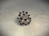 an image of a ring with blue and white crystals on a white surface