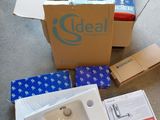 une pile de cartons et un évier posé à même le sol