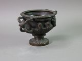 a bronze vase with a dragon on it on a table