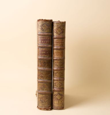 deux vieux livres posés l'un sur l'autre sur une surface blanche