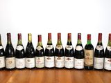 de nombreuses bouteilles de vin alignées sur une table en bois