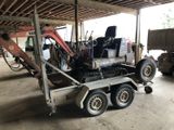 un camion avec un tracteur à l'arrière, dans un garage