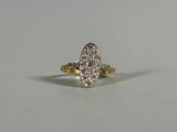 une bague en or et diamants posée sur une surface blanche