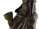 statue of a woman sitting on a stool with a basket in her hand