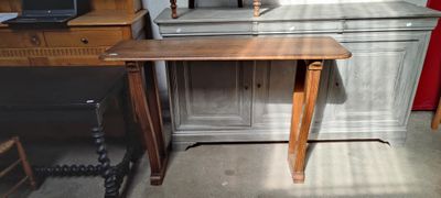 une petite table sur laquelle est posé un ordinateur portable, dans une pièce
