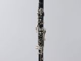 a close up of a black and silver clarinet on a clear stand