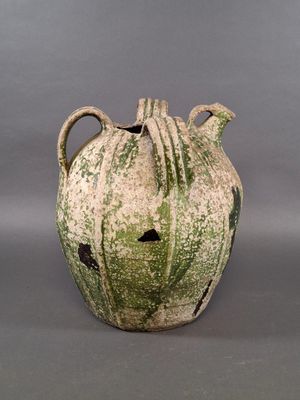 a green and white vase sitting on a gray surface