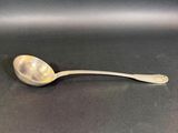 silver spoon on a black surface with a small spoon in the middle of it