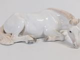 porcelain figurine of a white horse laying down on a white surface