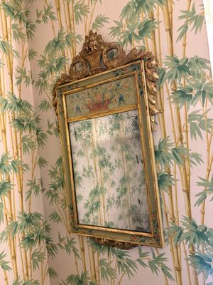 un miroir accroché au mur au-dessus d'un lavabo dans une salle de bains