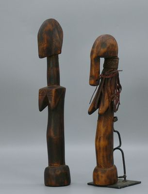 deux sculptures en bois représentant un homme et une femme, posées sur un socle