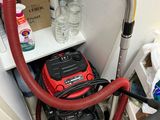 a vacuum that is sitting on the floor next to a shelf