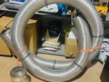 a large metal hose sitting on the floor next to a can of soda