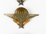three military badges on a white surface with a white background