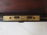 a close up of a wooden desk with a brass plate on it
