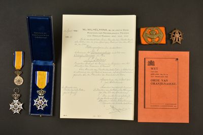 une photo montrant un document, une médaille et d'autres objets posés sur une table