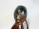 a brown and black vase with a black handle