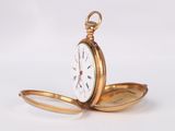 a gold pocket watch sitting on a white surface
