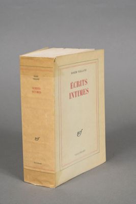 an old book sitting on top of a table on a gray surface