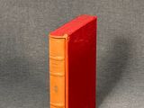 an orange book sitting on top of a gray surface