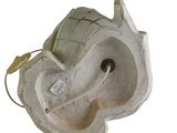 underside view of a white ceramic elephant head with a light bulb attached