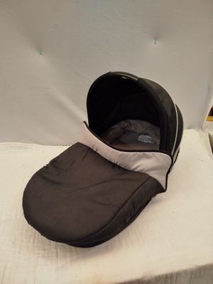 un bébé endormi dans une poussette posée sur un lit