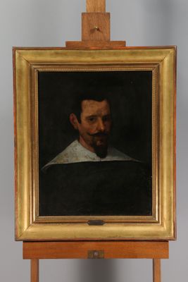 painting of a man with a beard and a white collar on a wooden easel