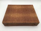 a brown alligator skin box with a lid on a white background