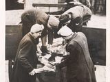 many men standing around a table with food on it